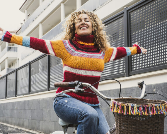 woman in a sweater smiling on her bike